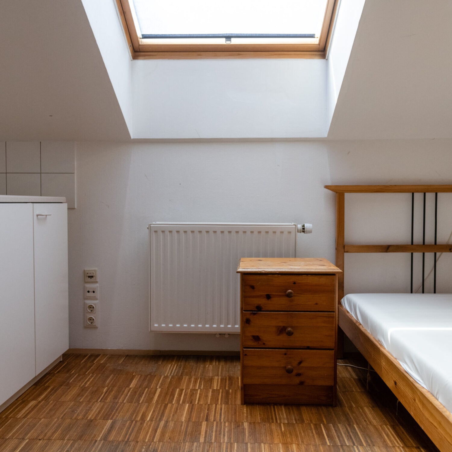 Eine leere Wohnung im neunerhaus Billrothstraße mit Bett, Kommode, Küche und Fenster