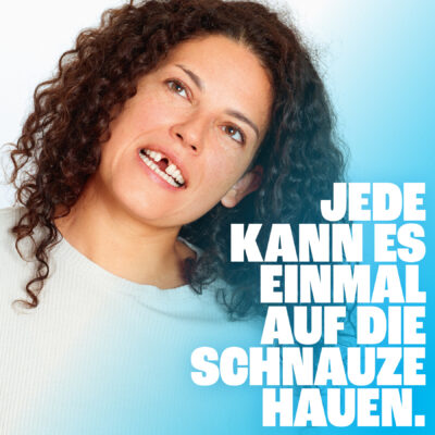 Claudia Kottal mit Zahnlücke für neunerhaus Kampagne Jede*n kann es einmal auf die Schnauze hauen